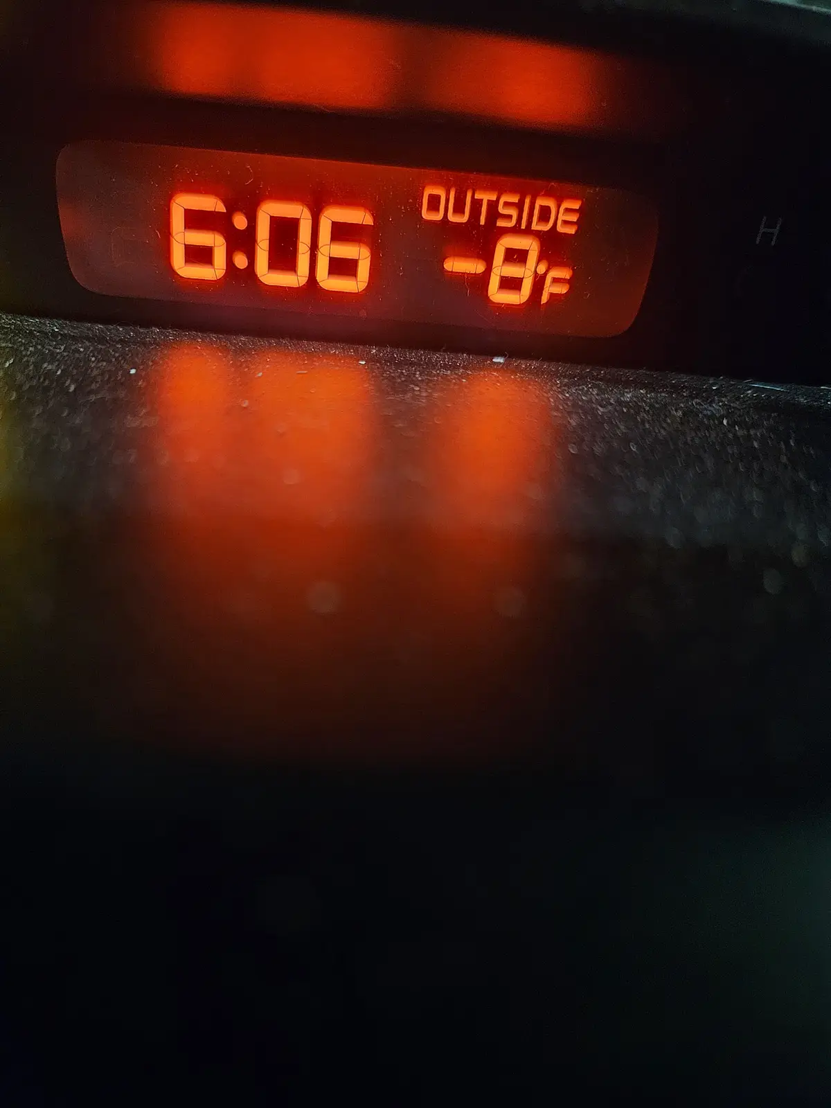 A close-up of a digital clock display showing the time as 6:06 and the outside temperature as -8°F, with the text 'OUTSIDE'…