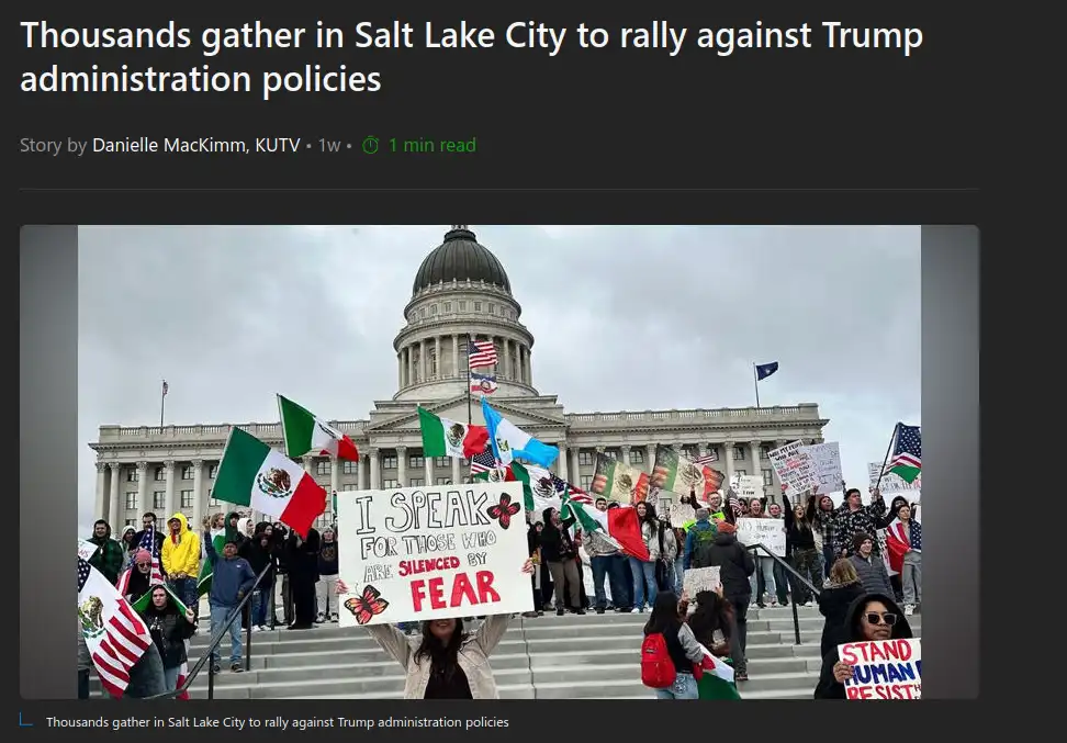 A crowd of protesters stands on the steps of a large domed government building, waving flags including American and Mexican…