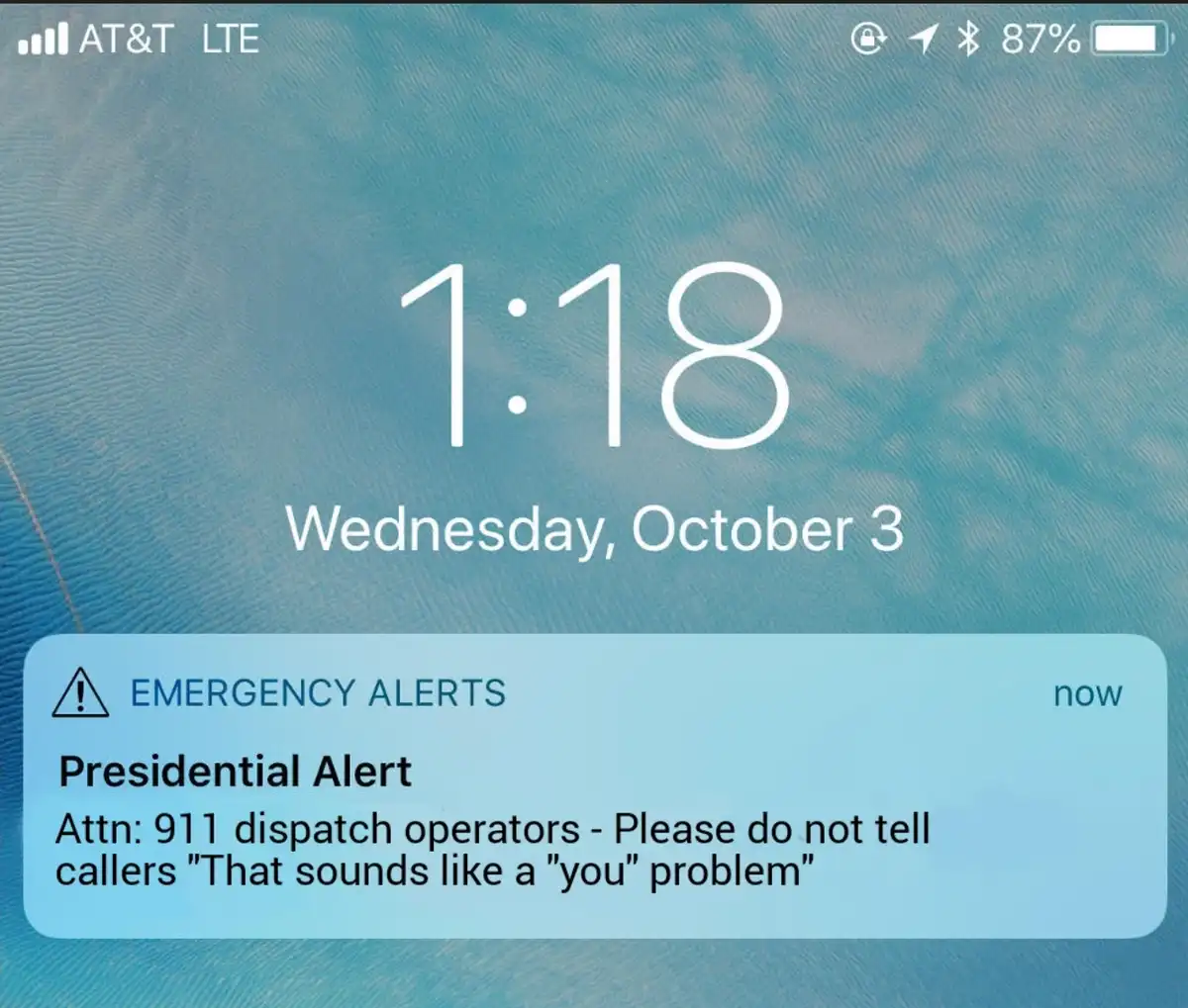 A smartphone lock screen shows a blue emergency alert notification for a 'Presidential Alert' with the text instructing 911…