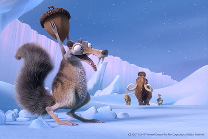 A cartoon squirrel with a large bushy tail and tusks is holding an acorn above its head in a snowy, icy landscape. In the…