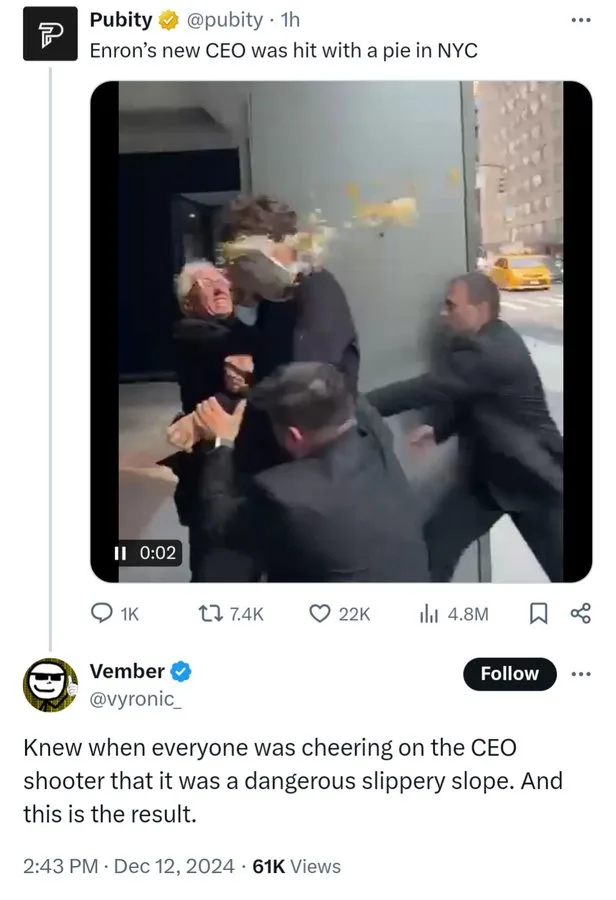 A man in a suit is being hit with a pie while surrounded by other men in suits, with a yellow taxi visible in the…