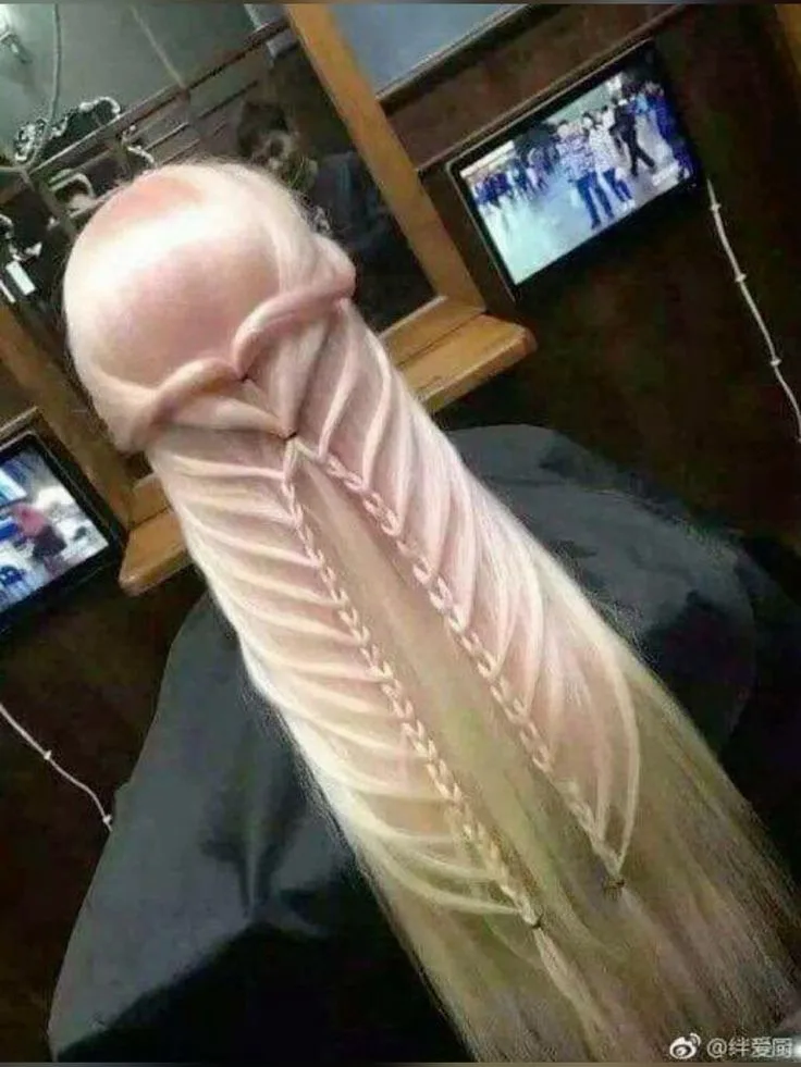 A person with very long, light blonde hair is shown from behind, sitting in a salon chair. Their hair is intricately braided…