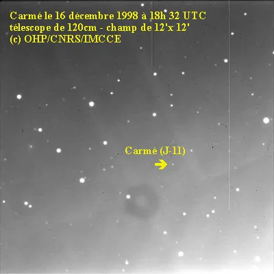 A grayscale astronomical photograph shows a starfield with a faint, blurry object labeled 'Carmé (J-11)' with an arrow…