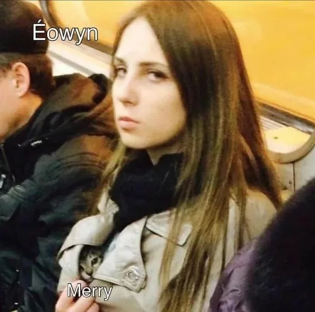 A woman with long brown hair, wearing a beige jacket and black scarf, sits on public transport looking annoyed. A small…