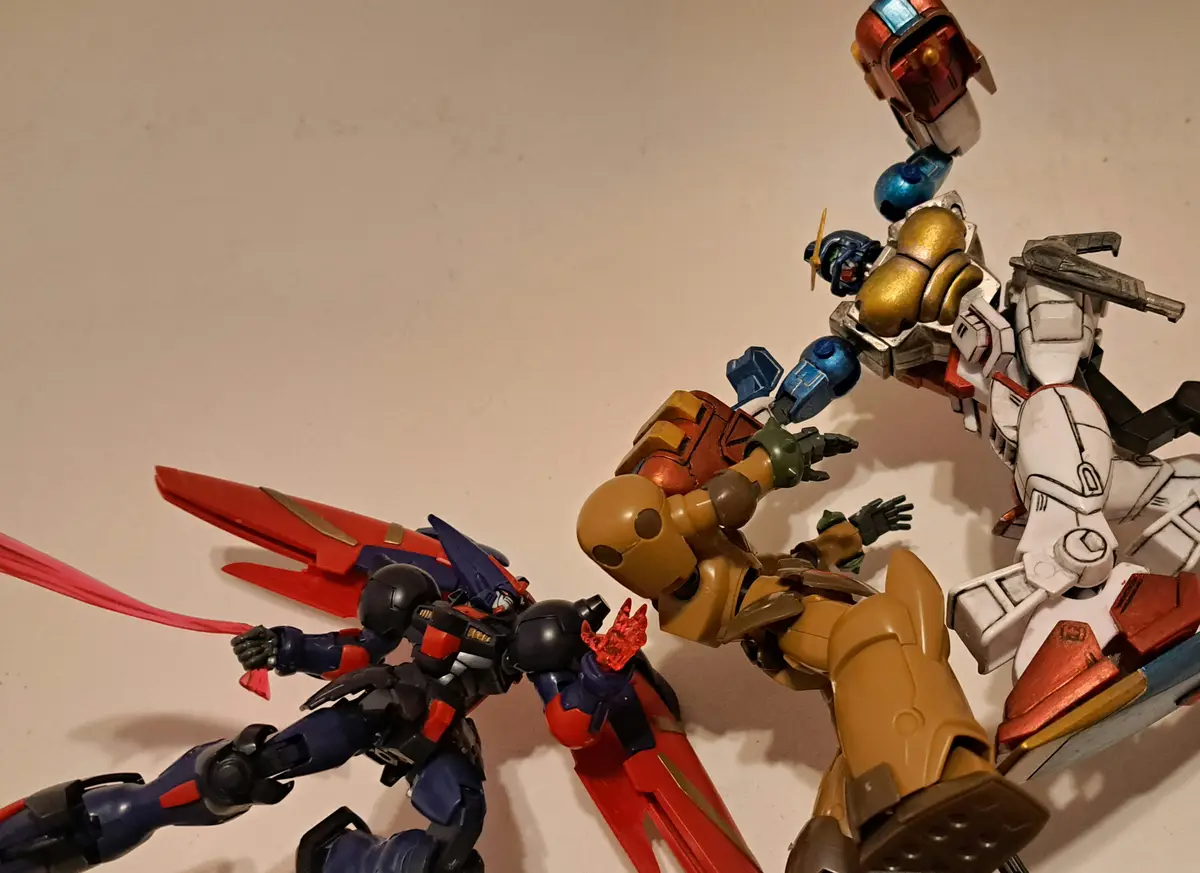 A photo of several plastic robot action figures posed in a chaotic, mid-fight arrangement on a plain surface. One…