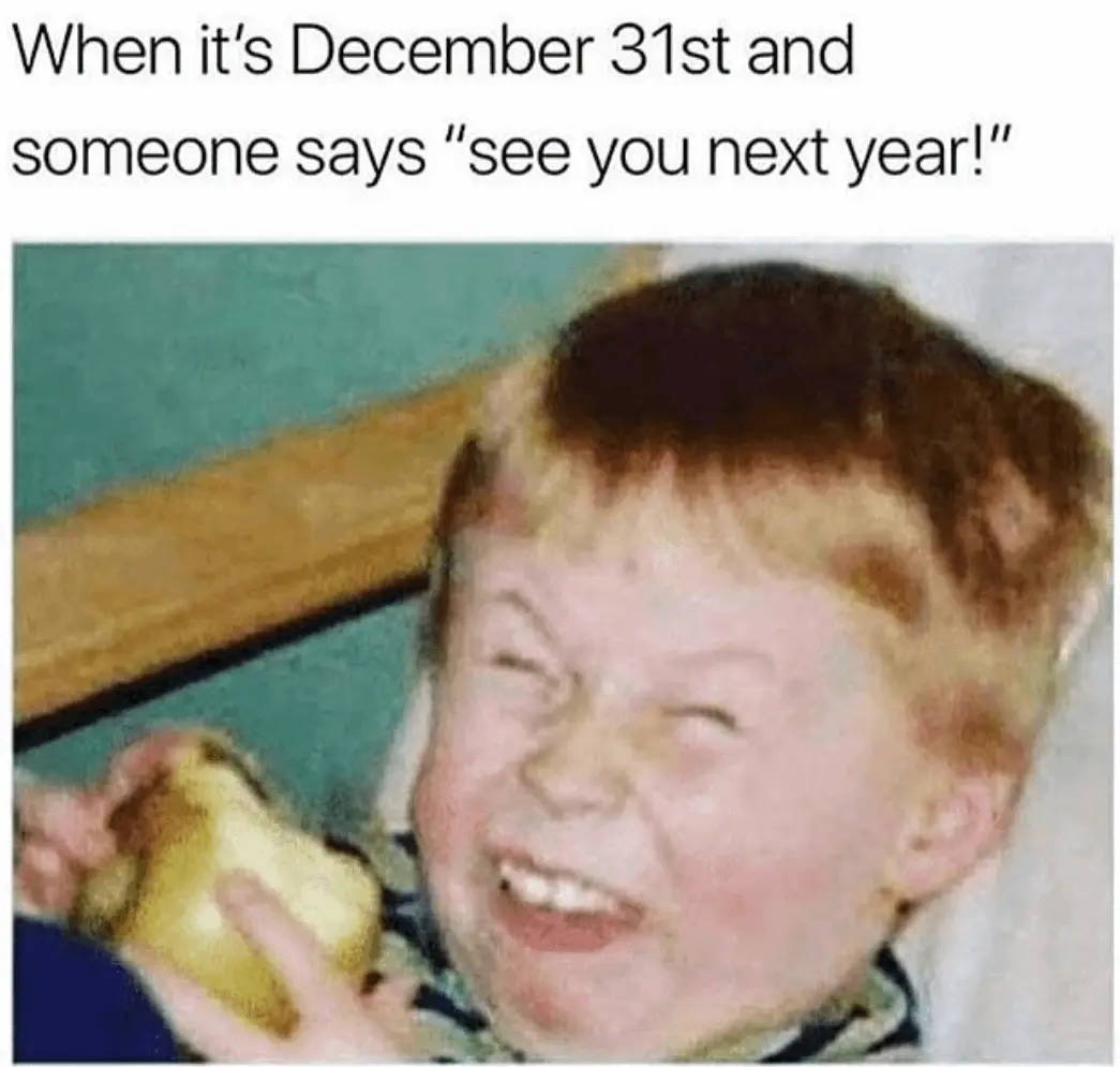 A blurry, low-resolution photo of a young child with reddish-blond hair, squinting and grinning widely while holding a…