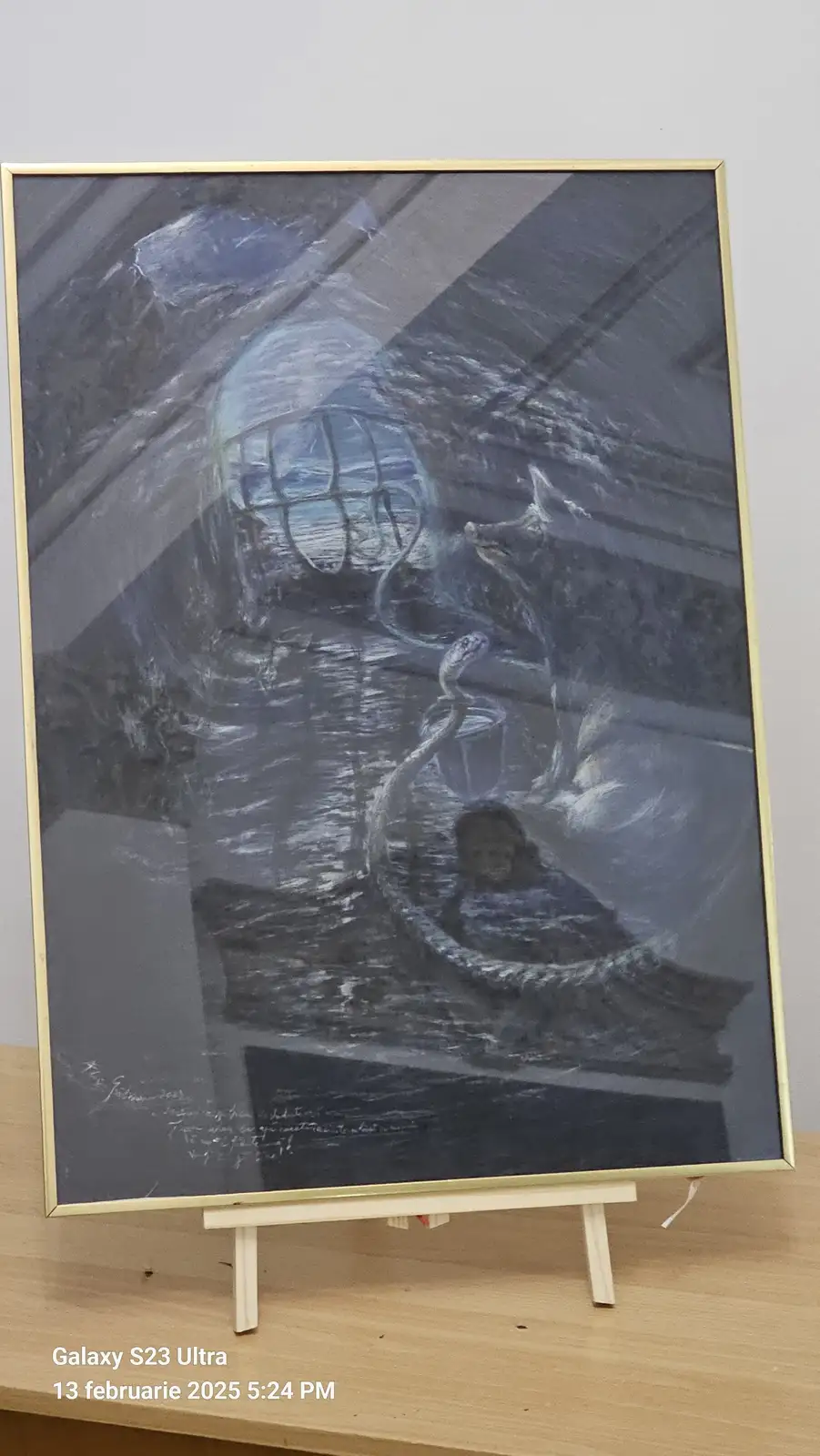 A framed, dark-toned chalk drawing depicts a surreal scene with a person in a boat, a large snake coiling around them, and a…