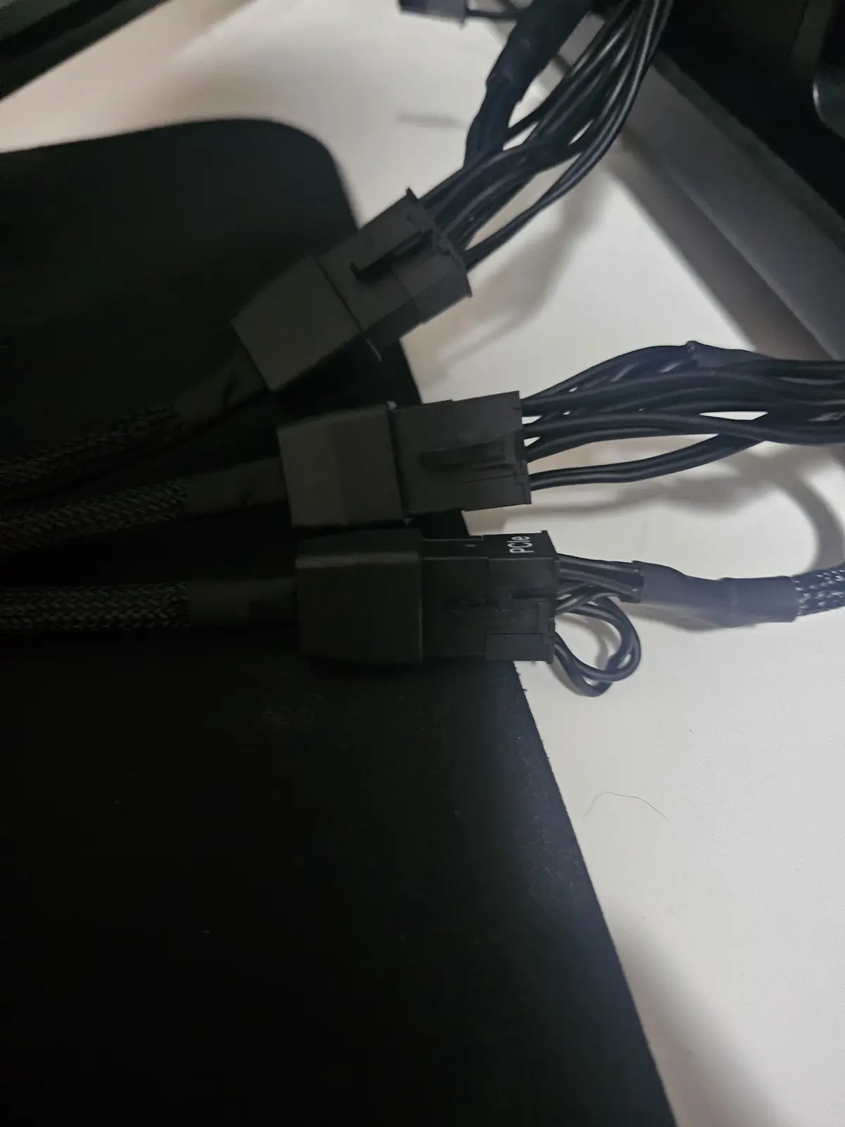 A close-up photo shows several black computer power cables with connectors, one of which is labeled 'Pcie' in white text…