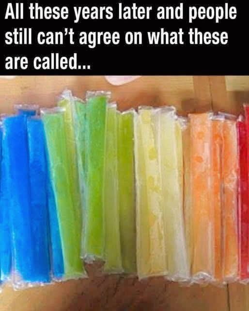 A row of colorful, individually wrapped frozen popsicles arranged in a rainbow gradient from blue to red, sitting on a…
