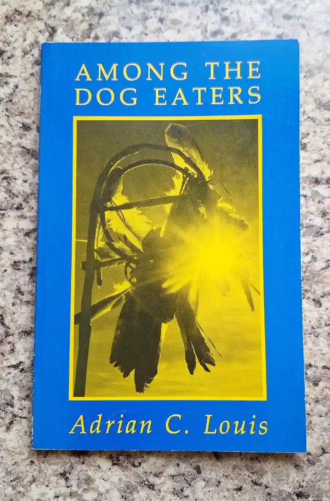 A book titled 'Among the Dog Eaters' by Adrian C. Louis, featuring a yellow-tinted cover image of a bird with feathers and a…