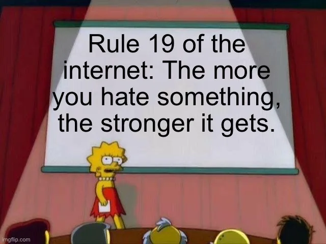 Lisa Simpson stands at a podium in front of a whiteboard in a classroom setting, looking serious as she presents. The…