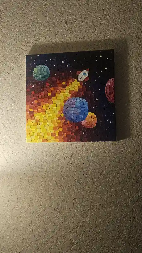 A painting on a wall depicts a space scene with planets, a rocket, and stars, but the entire image is rendered in a…