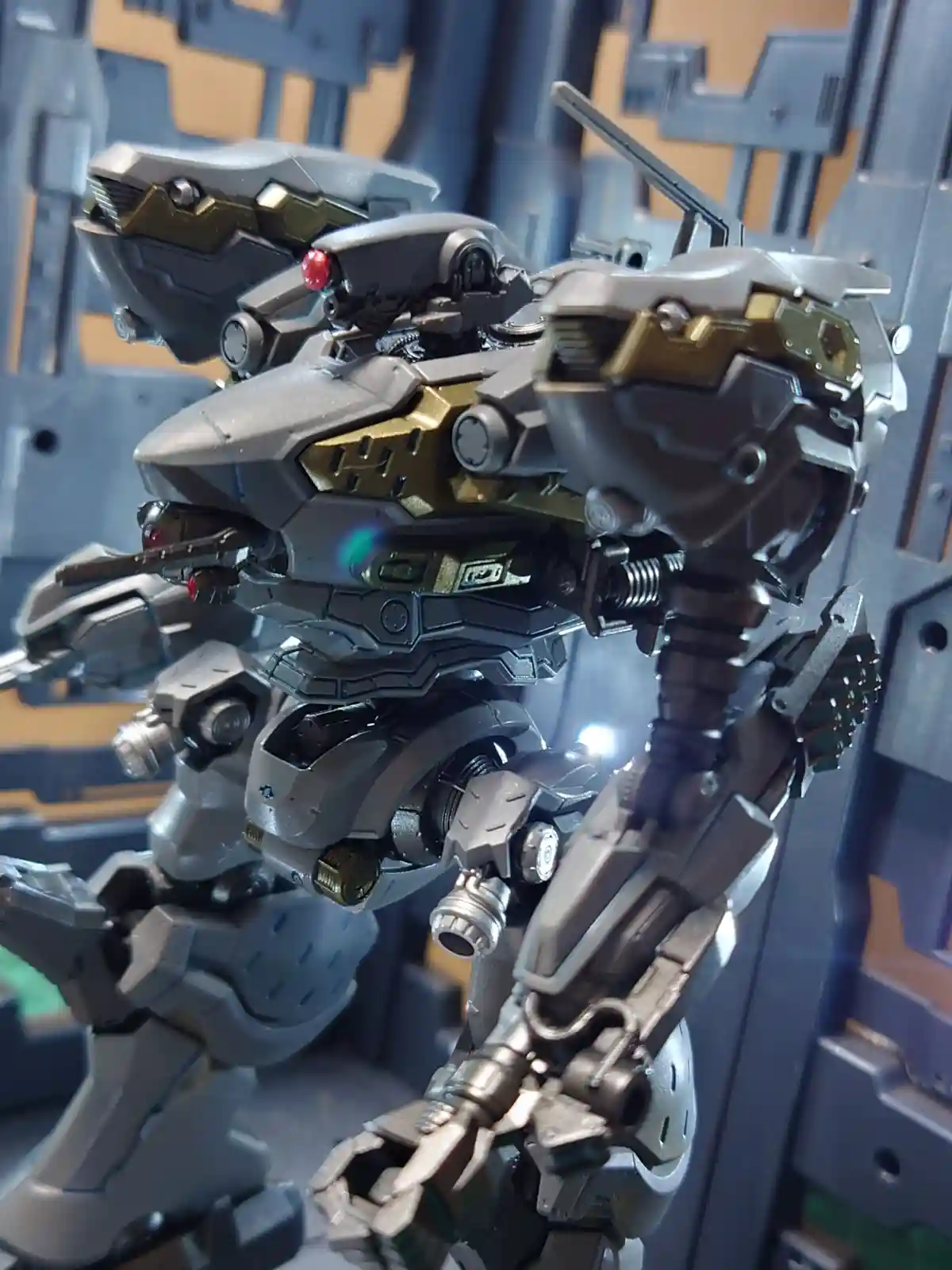 A highly detailed, grey and gold mechanical robot model with red glowing eyes and visible joints, posed in a dynamic stance…
