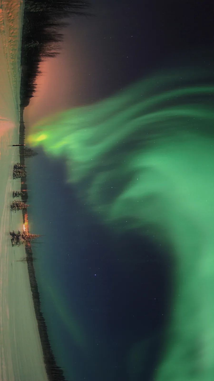 A stunning photograph of the aurora borealis, with vibrant green curtains of light dancing across a starry night sky over a…