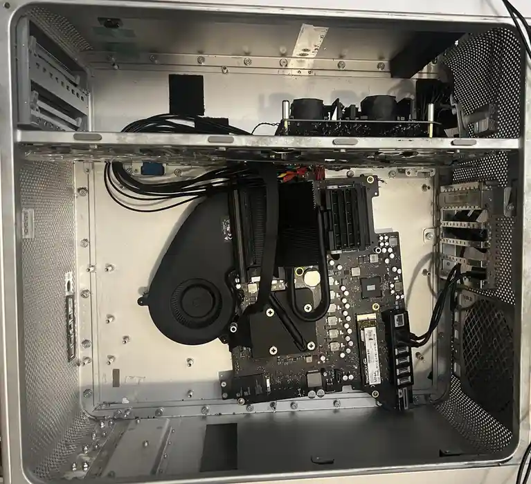 An overhead view of the inside of a silver computer case showing a motherboard, a large black liquid cooling system with…