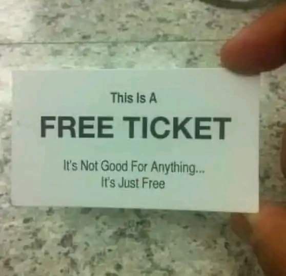A hand holds a white card with bold black text that reads 'This Is A FREE TICKET' followed by smaller text 'It's Not Good…