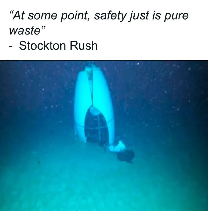 An underwater image shows a large, white, cylindrical submersible resting upright on the ocean floor, with a small dark…