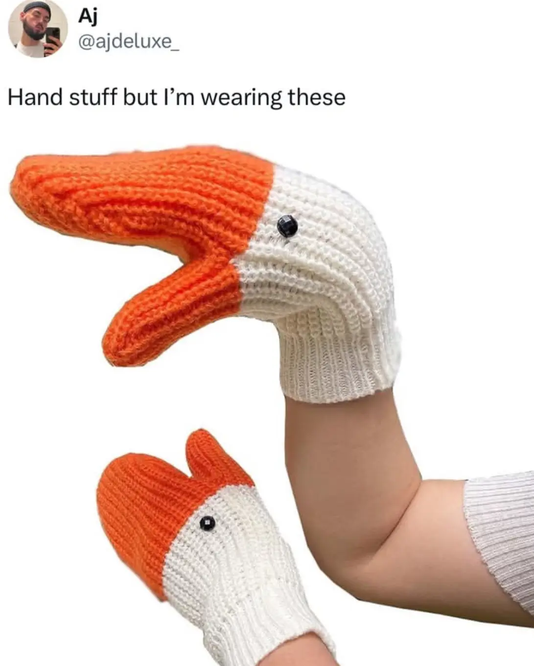 A person is wearing a pair of knitted mittens designed to look like duck heads, with orange beaks and white bodies, each…