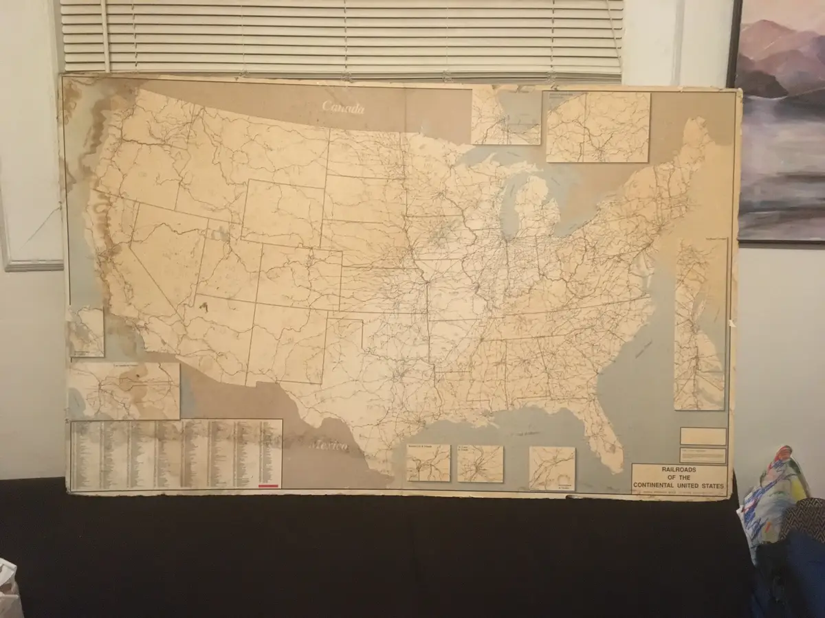 A large, aged, beige map titled 'Railroads of the Continental United States' shows a dense network of rail lines across the…