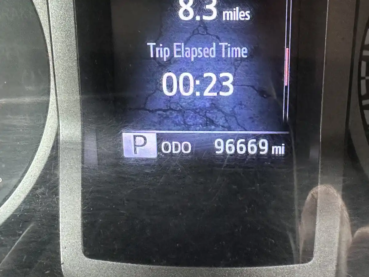 A close-up of a car's digital odometer screen showing 8.3 miles for a trip, 23 seconds elapsed time, and a total odometer…