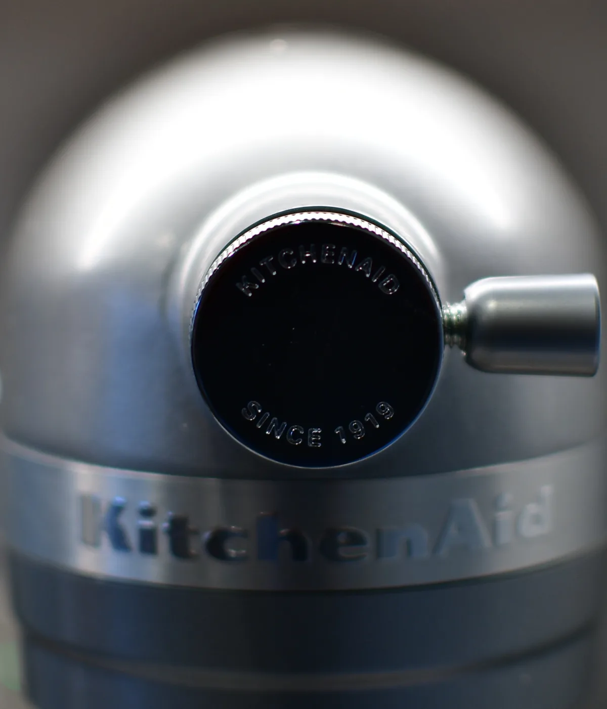 A close-up photo of a silver KitchenAid appliance, focusing on its control knob which has 'KITCHENAID' and 'SINCE 1919'…