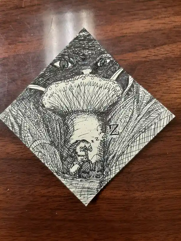 A black-and-white ink drawing on a diamond-shaped card shows a large, menacing cat with wide eyes and a gaping mouth…