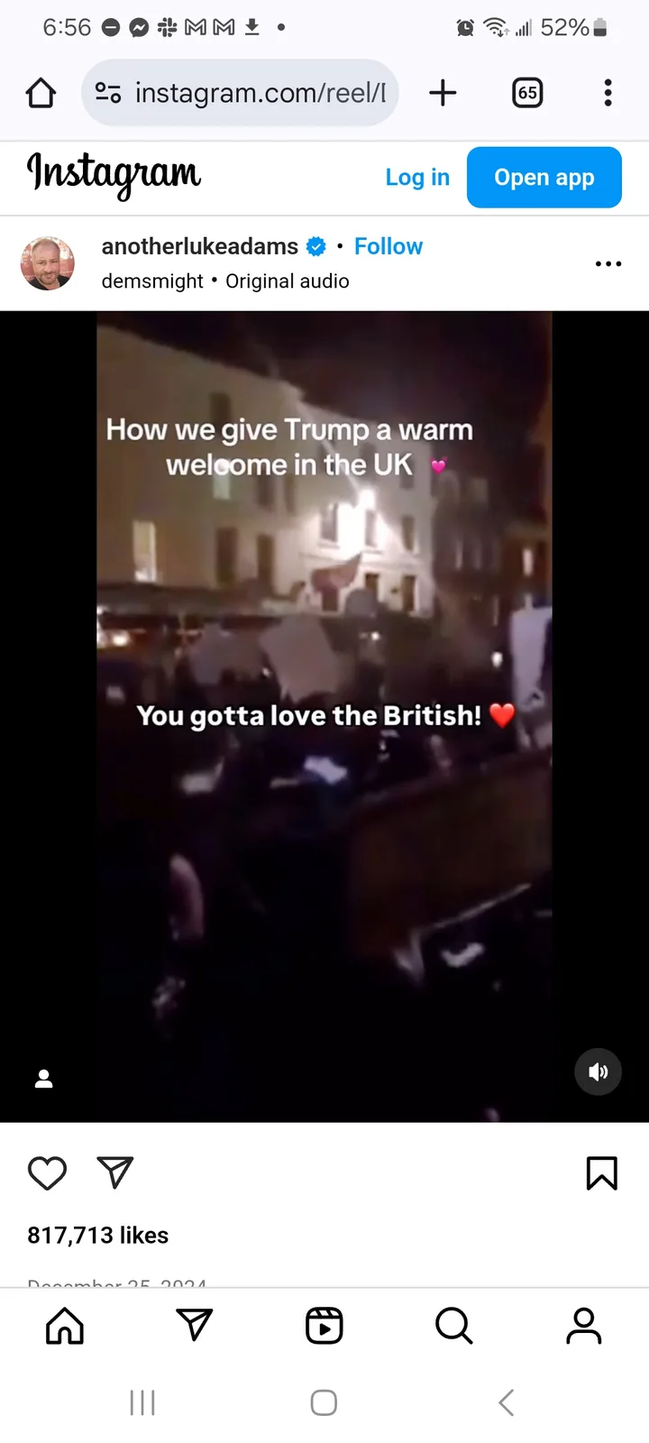 A blurry nighttime video shows a crowd of people holding signs in front of a building with lights on. Overlaid white text…