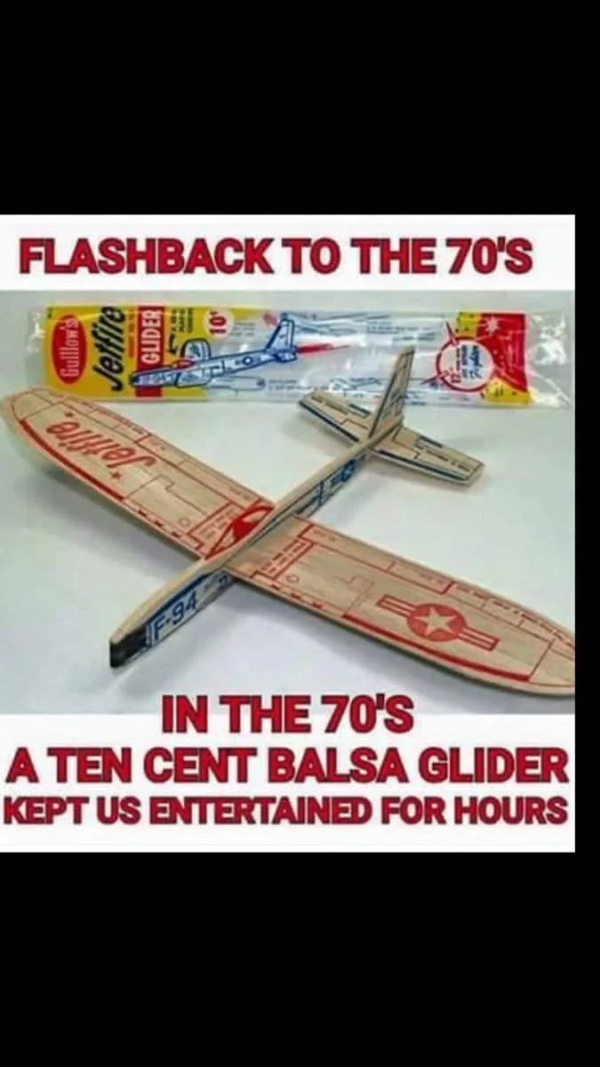 A vintage 1970s Guillow's Jettile 10' balsa wood glider airplane is shown next to its original plastic packaging. The image…