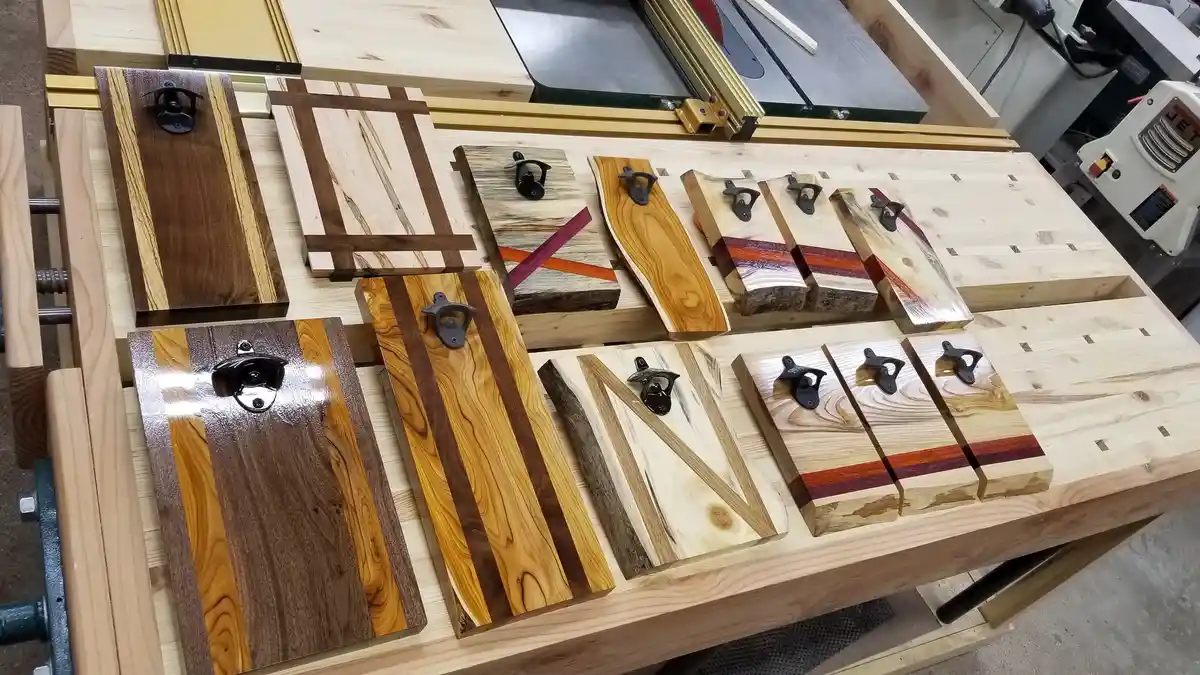 A woodworking workshop scene displays several custom-made wooden blocks arranged to spell out the word 'MAN'. Each block is…