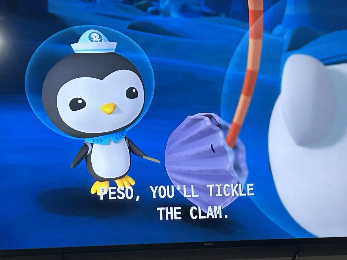 A cartoon penguin in a blue diving helmet and scarf stands next to a purple clam shell underwater. The overlaid text reads…