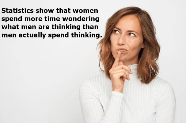 A woman with brown hair wearing a white ribbed sweater looks thoughtfully to her right, her finger pressed to her lips…