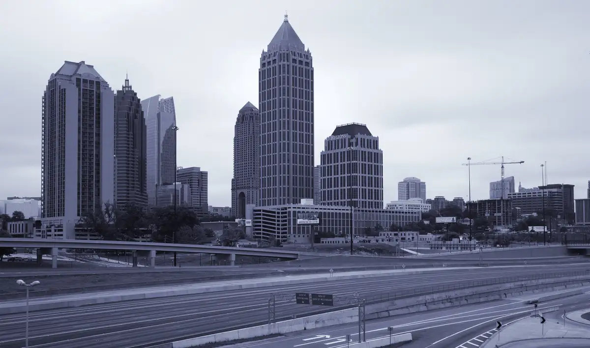 A desaturated photo of a city skyline with tall buildings and an empty highway in the foreground. Overlaid text reads 'i'm…