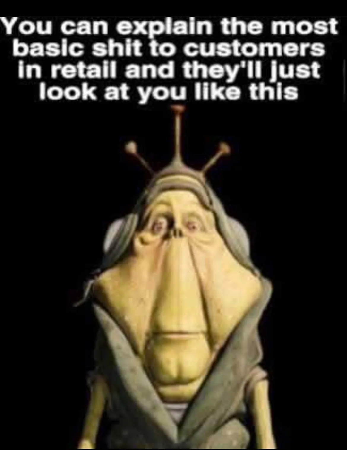 A close-up image of a cartoonish alien character with three antennae, wearing a hooded robe, against a black background. The…