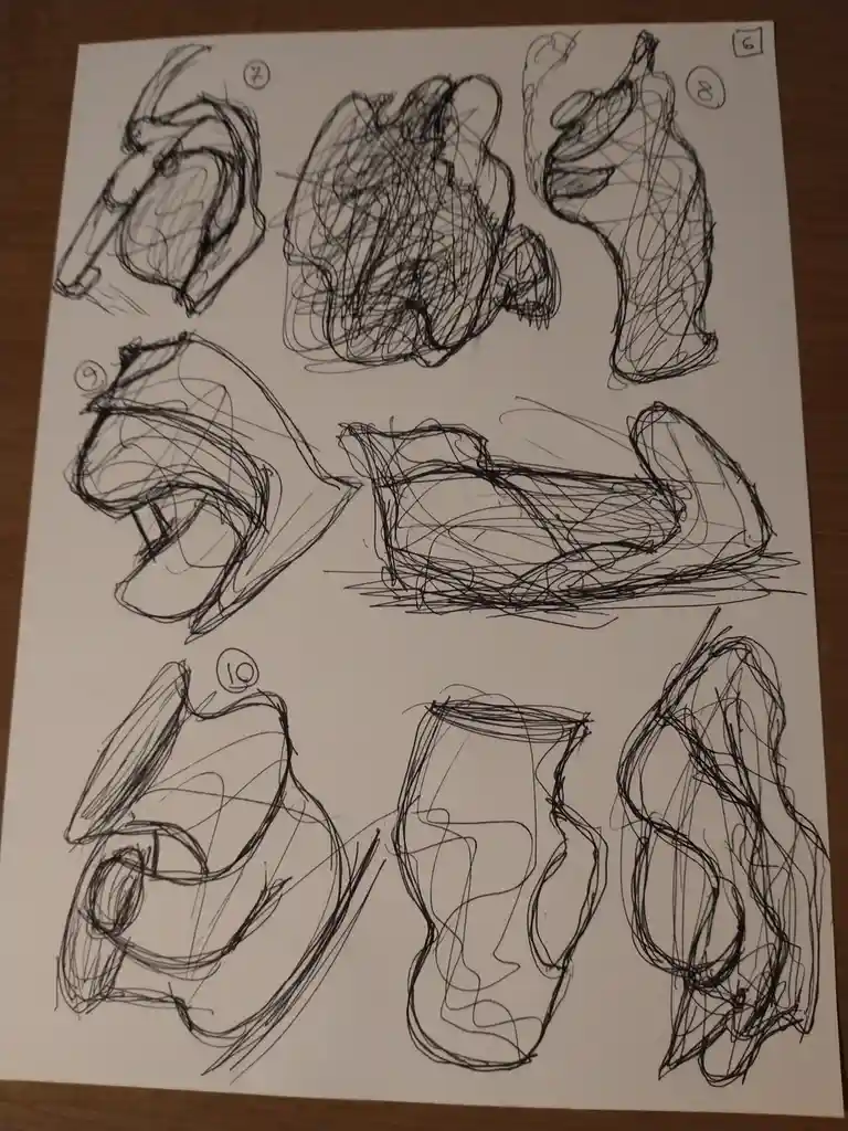 A white paper with nine messy, abstract black ink sketches of human faces and heads, each labeled with a circled number from…