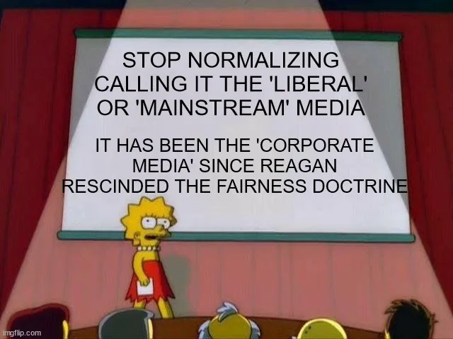 A still from The Simpsons shows Lisa Simpson standing at a podium in front of a projector screen displaying the text. The…