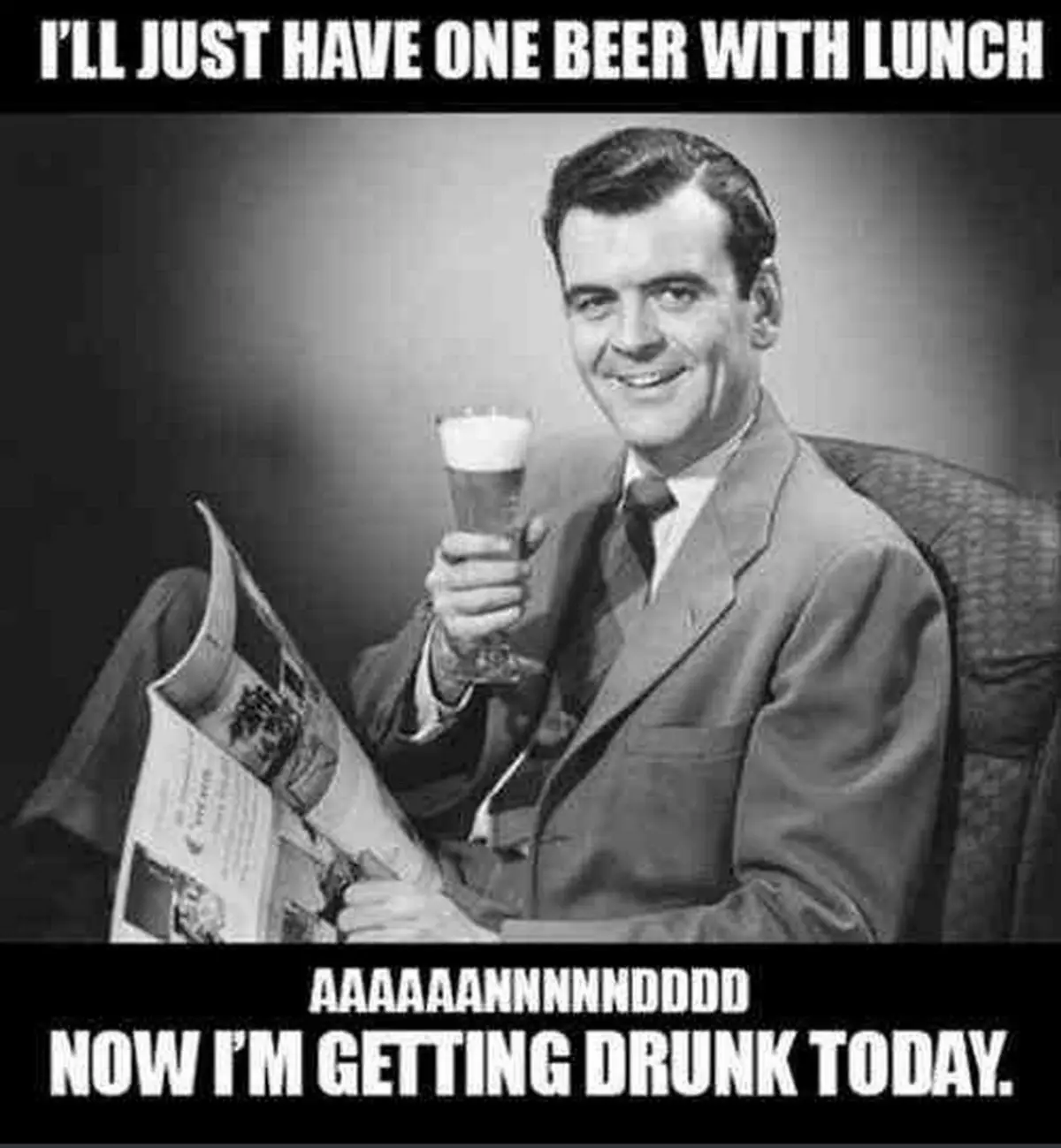 A black-and-white photo of a smiling man in a suit sitting in a chair, holding a glass of beer in one hand and a newspaper…