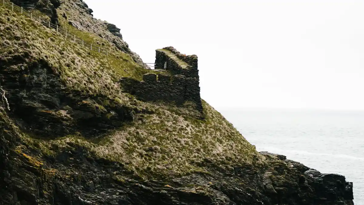 Crashing waves below, wind-whipped sea spray mingles with the scent of salt and damp earth. Ancient stone ruins cling to the…