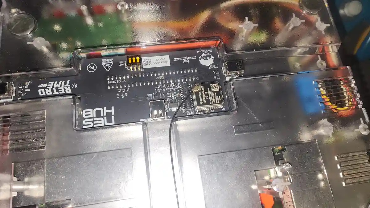 A close-up photo of an open electronic device, likely a retro gaming console, showing a black circuit board labeled 'NES…