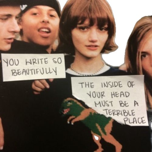 A collage of four people, one holding a sign that reads 'YOU WRITE SO BEAUTIFULLY' and another holding a torn sign that…