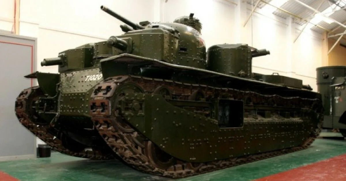 a large, olive-green military tank with multiple mounted cannons and the number 71020 on its side, displayed indoors on a…