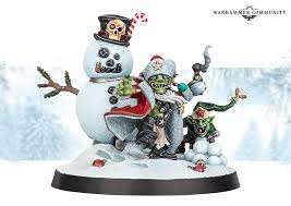 A Warhammer 40k miniature scene shows a snowman with a skull face and candy cane hat, alongside two green-skinned…