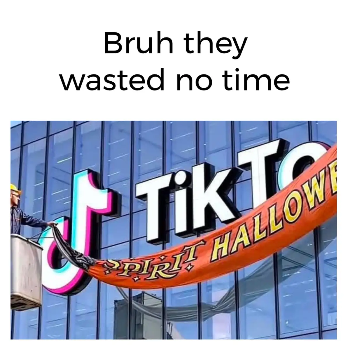 A worker in a cherry picker is attaching a Halloween-themed banner to the TikTok corporate building, which already has the…