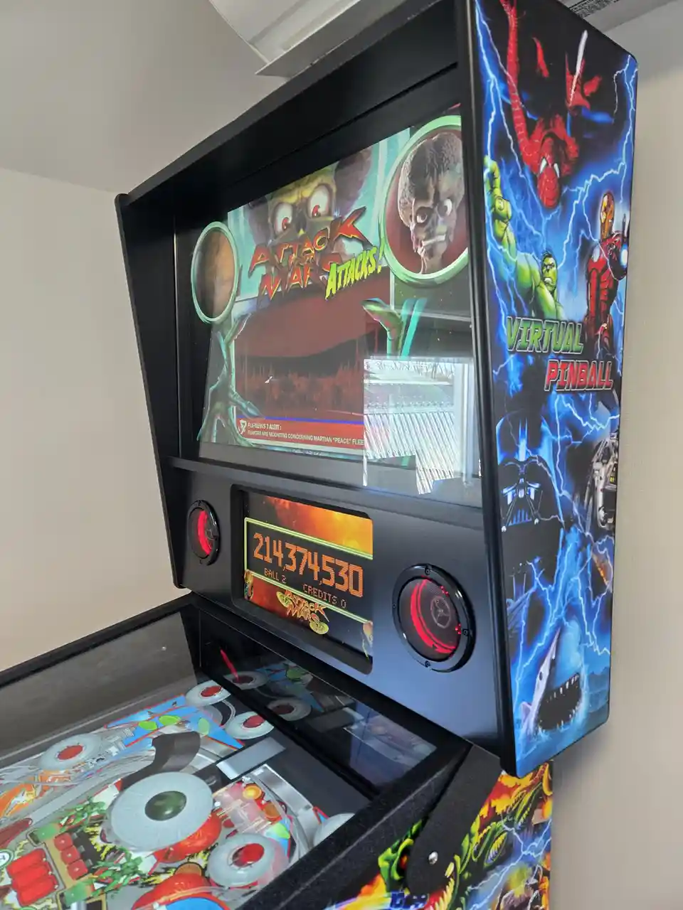 A pinball machine themed 'Attack from Mars' displays an absurdly high score of 214,374,530 on its digital screen, with the…