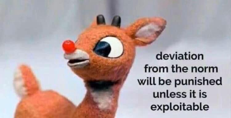 A close-up of a brown, felt-like Rudolph the Red-Nosed Reindeer plush toy with a red nose, looking upward with wide eyes…