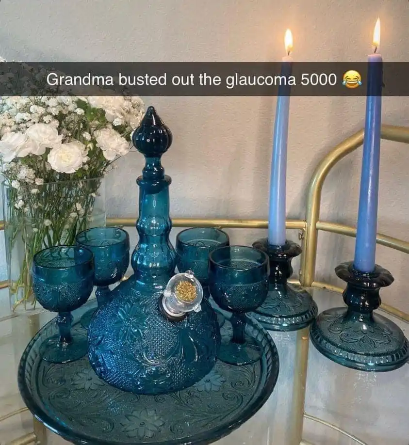 A decorative set of blue glassware, including a decanter and matching glasses on an ornate tray, is displayed on a mirrored…