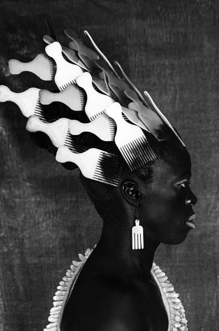 A black-and-white portrait of a woman in profile, her head adorned with numerous white plastic combs arranged like a crown…