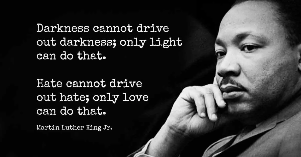 A black and white photo of Martin Luther King Jr. looking thoughtful with his hand on his chin. Overlaid text displays two…
