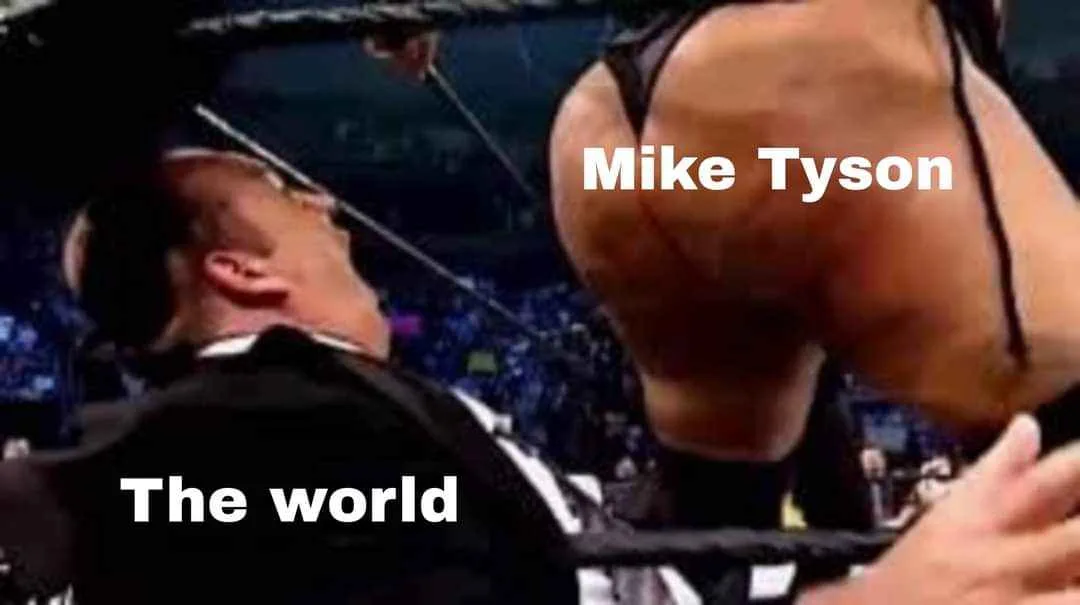 A man in a suit labeled 'The world' is shown looking up at the backside of a muscular man in wrestling attire labeled 'Mike…