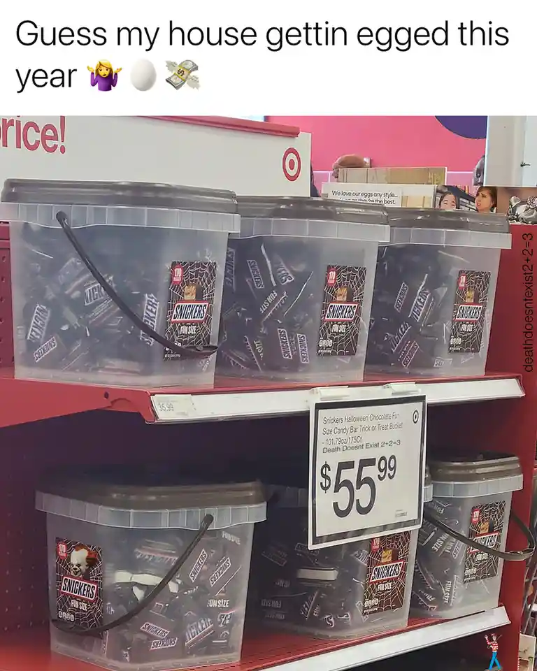 A photo of Halloween candy buckets filled with Snickers bars on store shelves, with a price tag reading $55.99 and the…