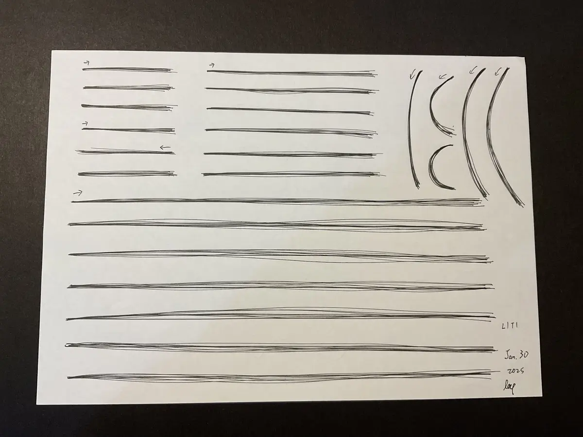 A white sheet of paper on a dark surface displays numerous hand-drawn black lines, some straight, some curved, with arrows…